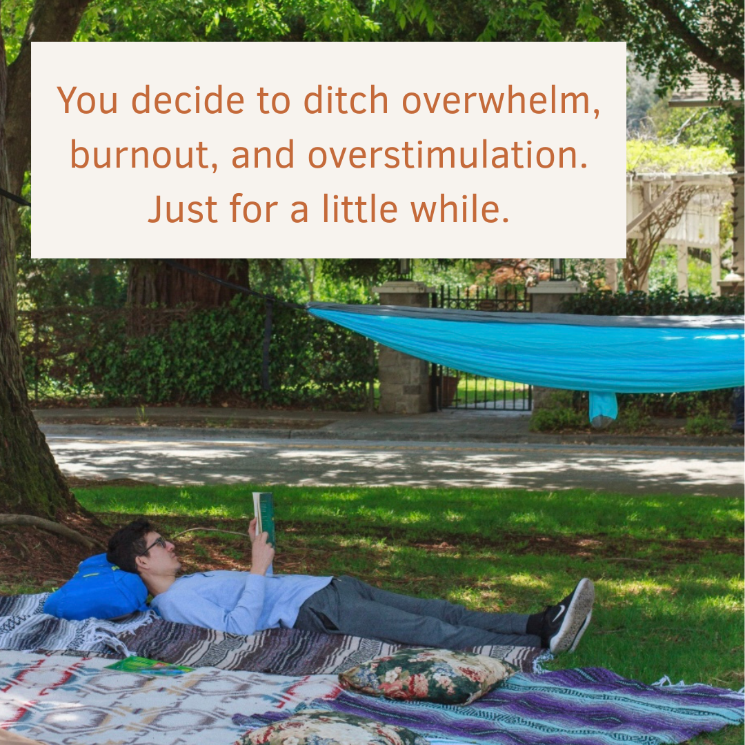 A young person resting on a blanket under a tree, reading
