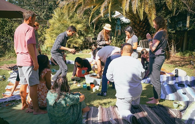 Community gathered on blankets in a sunny backyard